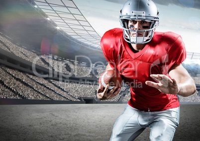 American football player holding ball while playing in pitch