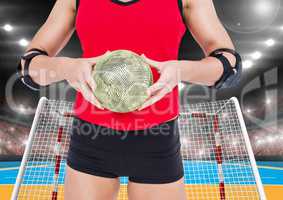 Mid section of a female handball player holding ball