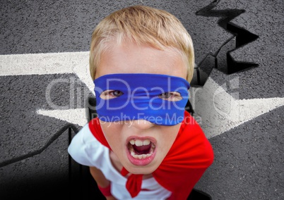 Portrait of aggressive super boy in red cape and blue mask on road