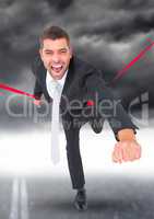 Businessman celebrating at finish line against stormy sky in background