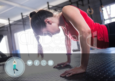 Fit woman performing push up exercise at gym with fitness interface