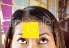 Close-up of woman with sticky note on her forehead