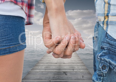 Couple standing on pier and holding hands