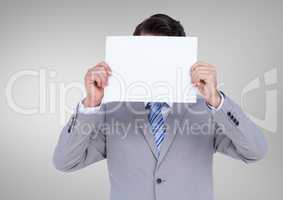 Businessman holding a blank paper in front of his face