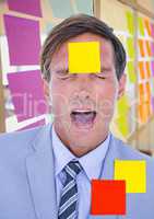 Stressed businessman with sticky notes on forehead