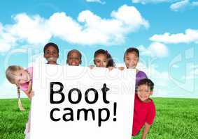 Kids holding card showing text  boot camp in front of blue sky and grass