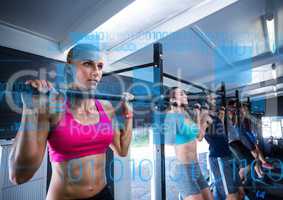 Fit people performing pull up exercise in gym