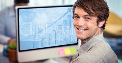 Portrait of smiling man working on computer at desk