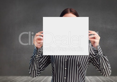 Businesswoman holding a blank placard in front of his face against grey background