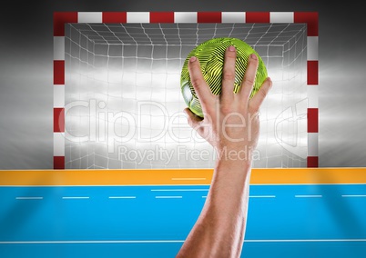Athlete throwing handball against stadium in background