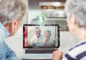 Senior couple having video call with friends on laptop