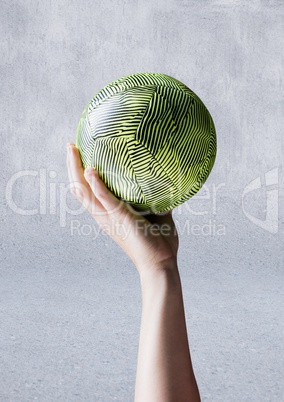 Hand of athlete holding ball against concrete background