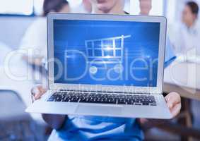 Man holding a laptop showing shopping cart on screen