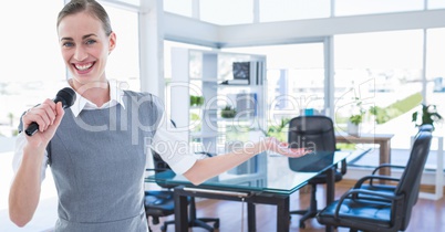 Businesswoman holding a mic and gesturing at office