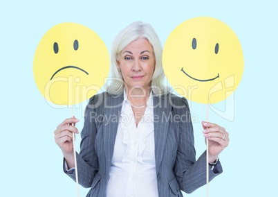 Businesswoman holding smiley and sad faces