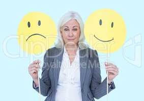 Businesswoman holding smiley and sad faces