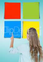 Woman touching colorful sticky notes against blue background