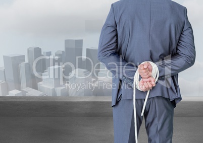 Digital composite image of a businessman with his hands tied behind the back