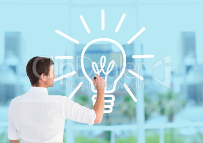 Businessman drawing a light bulb on a glass