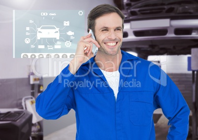 Happy automobile mechanic talking on mobile phone