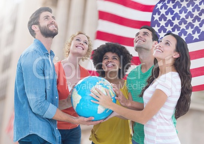 Group of happy people holding globe against American flag and looking up
