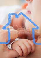 Mother hugging her child against house outline in background