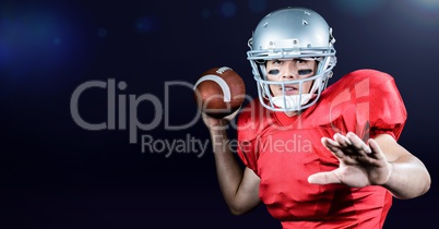 American football player throwing ball against blue background
