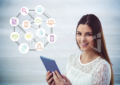 Woman using digital tablet against application icons in background