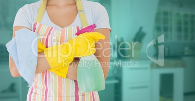 Cleaner standing with spray bottle in kitchen