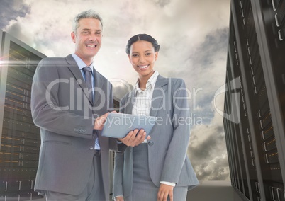 Portrait of smiling businesspeople using digital tablet against server background