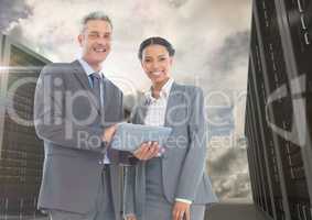 Portrait of smiling businesspeople using digital tablet against server background