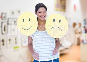 Woman holding happy and sad smiley faces