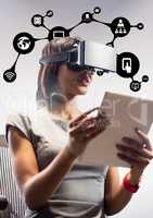 Woman using virtual reality headset and digital tablet against application icons