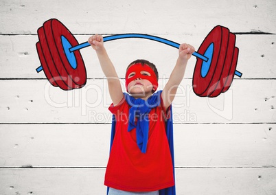 Boy in superhero costume pretending to lift weights against wooden background