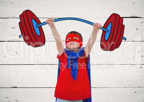 Boy in superhero costume pretending to lift weights against wooden background