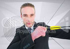 Businessman aiming with bow and arrow against target in background