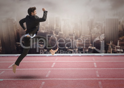Businessman running on race track against cityscape background