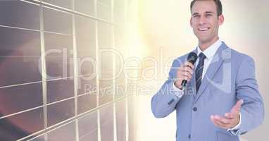 Businessman speaking with microphone against city building