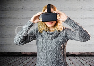 Woman using virtual reality headset against wall background