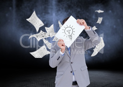 Businessman holding sheet of paper showing a light bulb and documents falling in background