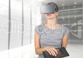 Businesswoman in virtual reality headset using digital tablet