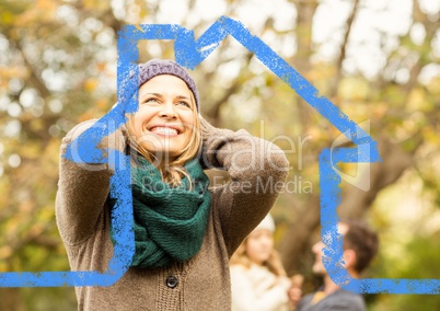 Cheerful woman overlaid with house shape in park
