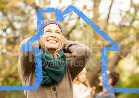 Cheerful woman overlaid with house shape in park