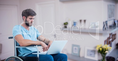 Man sitting on wheelchair and using laptop