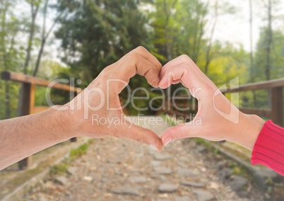 Close-up of couple showing hand heart gesture
