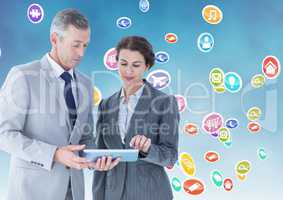 Businesspeople using digital tablet against multiple icons background