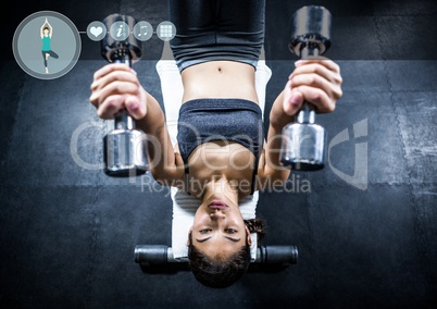 Fit woman perfroming flat bench exercise in gym against fitness interface i n background