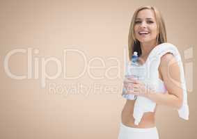 Fit woman holding a water bottle against beige background