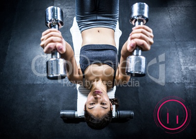 Woman working out with dumb bells and digital interface in background