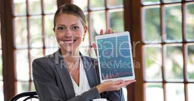 Woman holding digital tablet against window in background